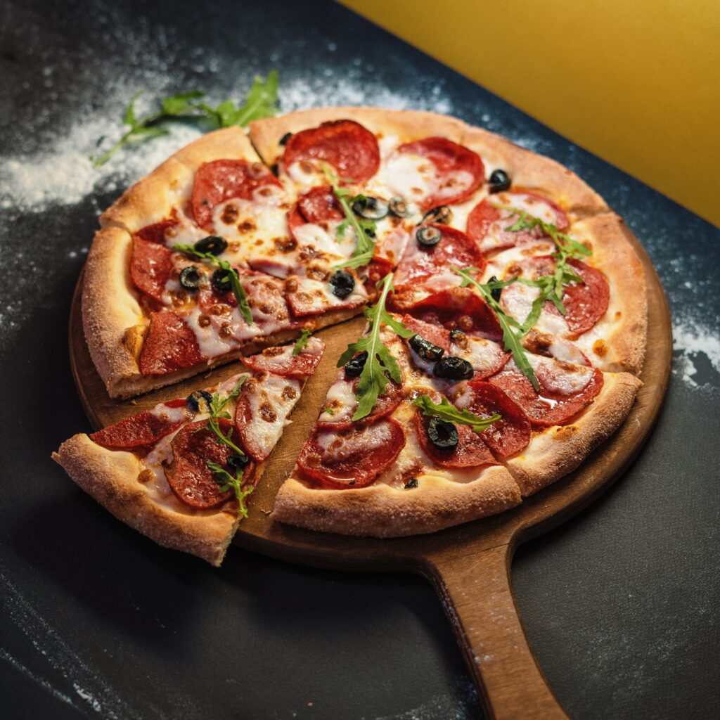 Zbliżenie świeżo upieczonej pizzy pepperoni z dodatkiem rukoli